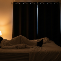 A calm bedroom showing good sleep hygiene with soft lighting and a tidy bed